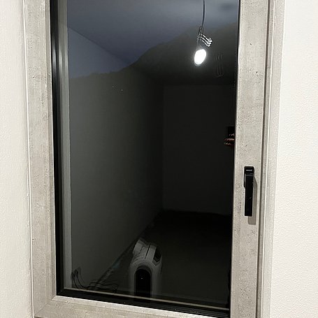 Innenfenster in Betonoptik mit schwarzem Griff